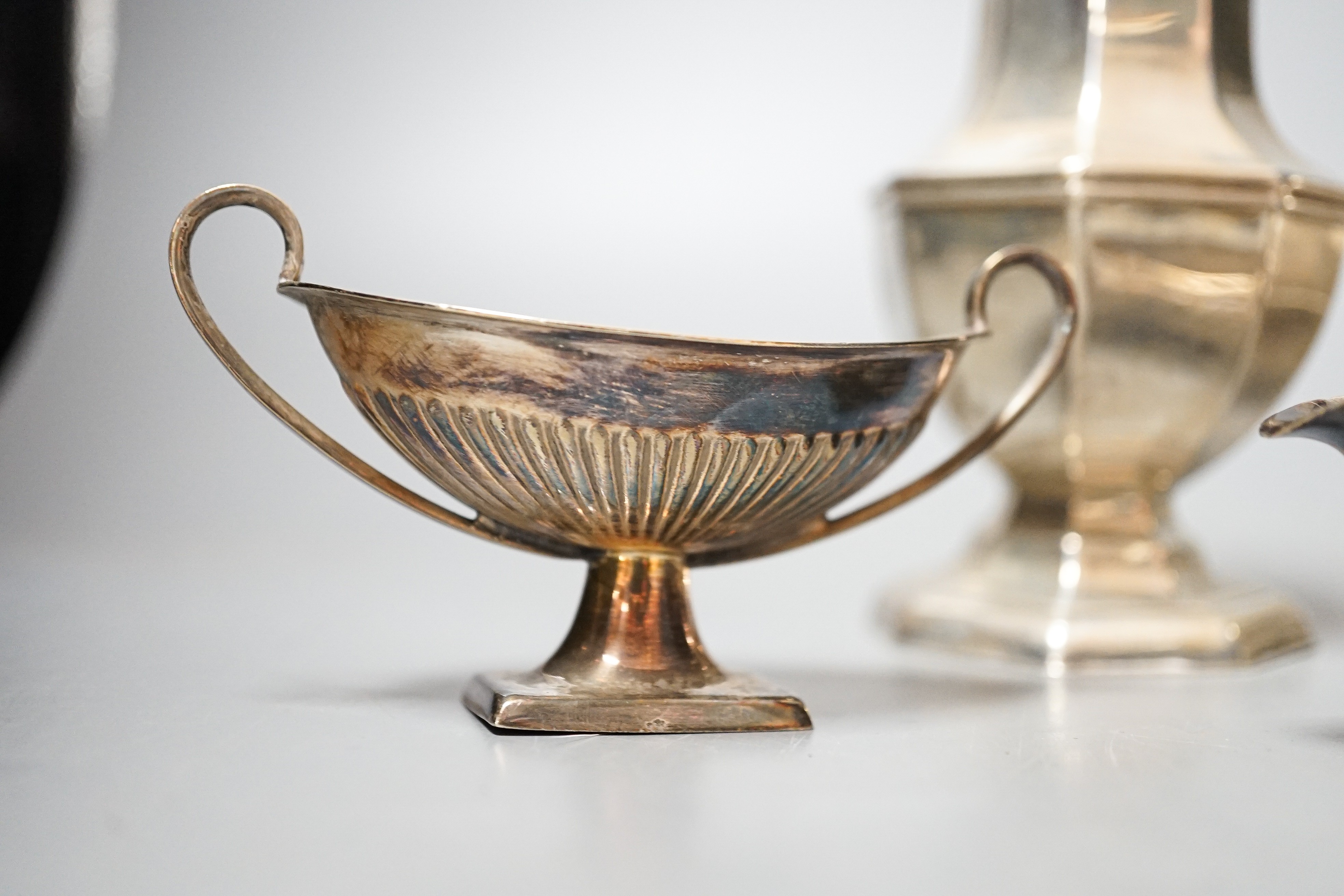 A George V silver sugar caster, 18cm, a silver globular pot with hinged cover, 9oz, a silver plated cream jug, sugar bowl, salt and spoon.